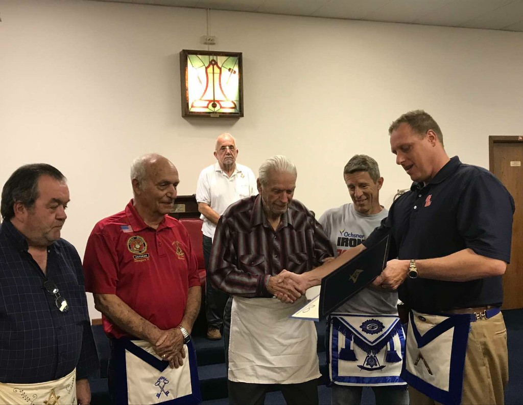 Worshipful Brother Stephen Dummer presenting a 50-year certificate to Worshipful Brother Noles Papa Esponge
